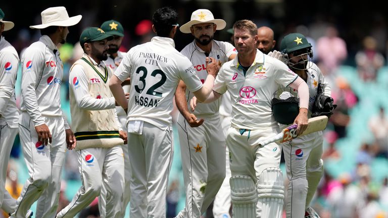El australiano David Warner, tercero a la derecha, es felicitado por los jugadores de Pakistán mientras sale del campo en el cuarto día de su partido de prueba de cricket en Sydney.