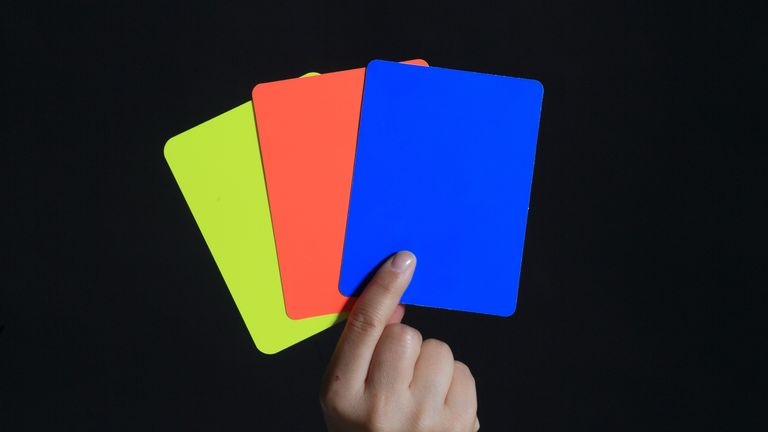 ILLUSTRATION - A yellow, red and blue card being held up in Magdeburg, Germany, 1 July 2016. The new handball rules of the International Handball Federation IHF now include a blue card, next to the yellow and red one. In order to make clear wether a red card will be followed by a decision of the disciplinary commission, the referee will hold up a blue card right after the red card. 