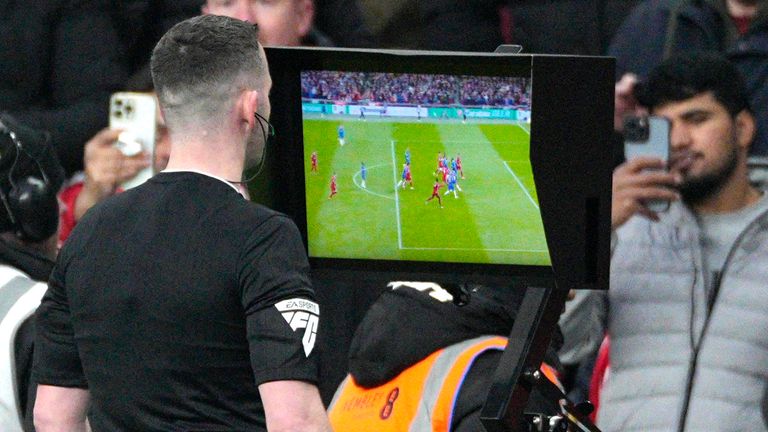 Referee Chris Kavanagh watches a replay of the Liverpool goal before ruling it out for 'technical offside'