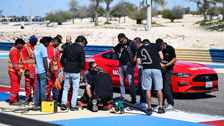 BAHRAIN INTERNATIONAL CIRCUIT, BAHRAIN - FEBRUARY 22: Marshalls and race control work to fix a loose drain cover during the Pre-Season Test at Bahrain International Circuit on Thursday February 22, 2024 in Sakhir, Bahrain. (Photo by Simon Galloway / LAT Images)