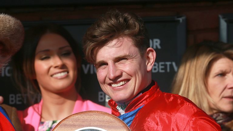 Jamie Moore receives his trophy after victory in the Queen Mother Champion Chase