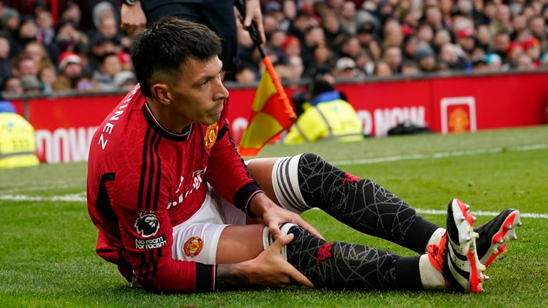 Manchester United's Lisandro Martinez holds his knee after an injury