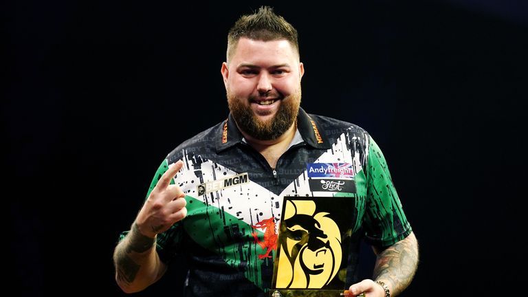 Michael Smith celebrates with his trophy after beating Gerwyn Price (not pictured) in the final during night one of the 2024 BetMGM Premier League at the Utilita Arena Cardiff. Picture date: Thursday February 1, 2024.