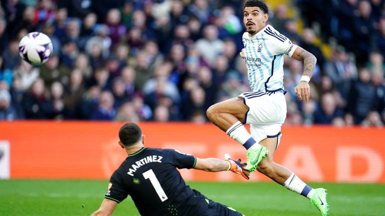 Morgan Gibbs-White lifts his shot over the onrushing Emi Martinez