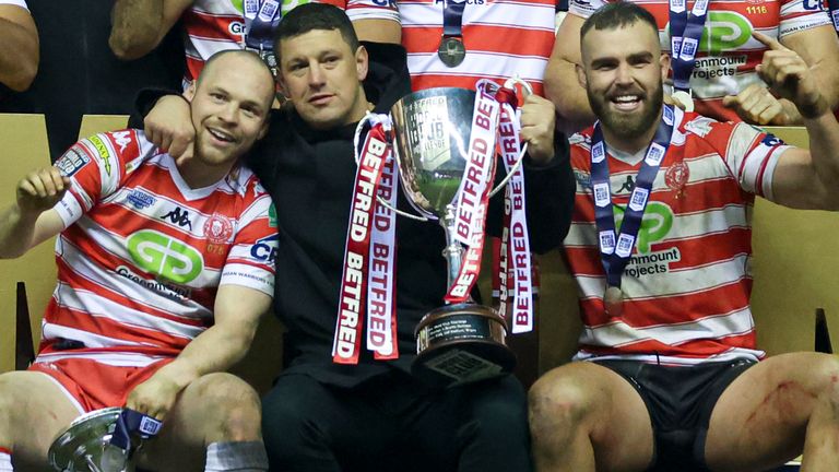 Wigan Warriors head coach Matt Peet celebrates with his players and the World Club Challenge trophy