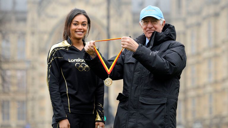 Lord Richard Layard awards London 2012 Olympic Stadium cauldron lighter Tracey with a 'Happy Hero' gold medal as part of a United Nations event in 2013