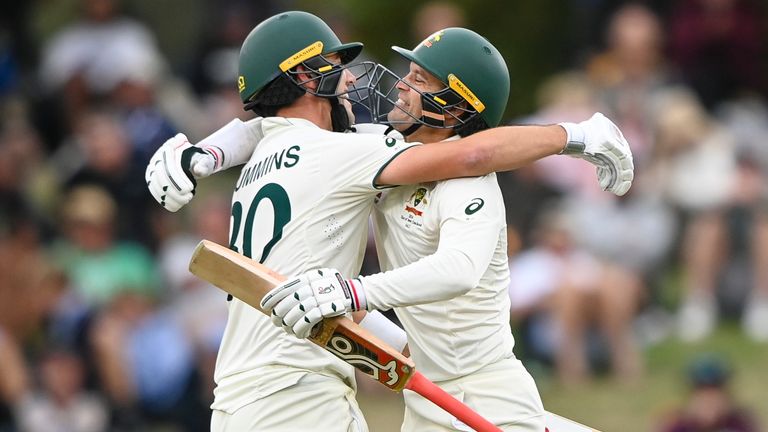 Australia's Alex Carey, right, and Pat Cummins celebrate after beating New Zealand