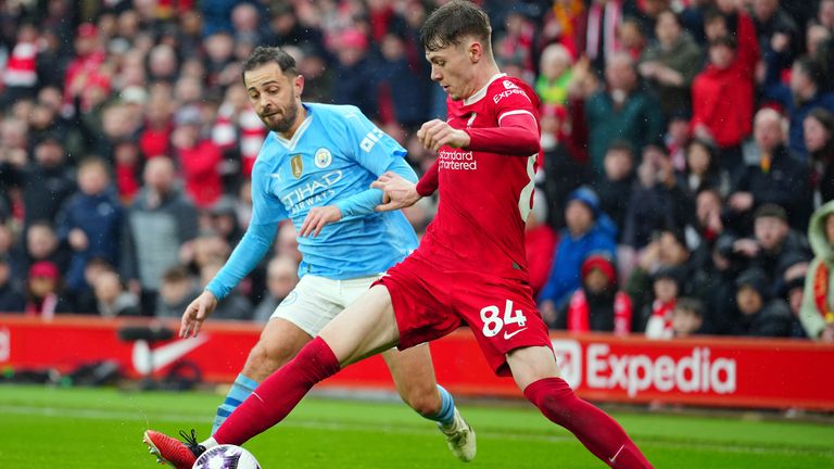 Liverpool's Conor Bradley, foreground, controls the ball as Manchester City's Bernardo Silva tries to stop him