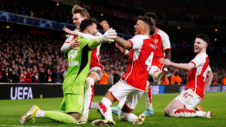 David Raya is mobbed by his Arsenal team-mates after his penalty saves in the shootout