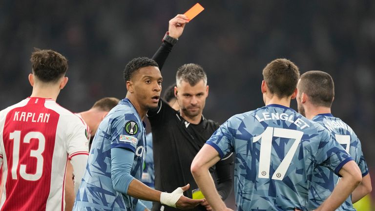 Aston Villa's Ezri Konsa, left, is shown a red card for a second bookable offence