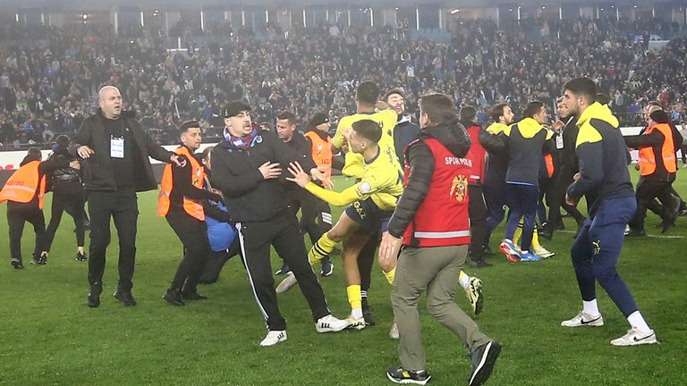 Fenerbahce's players clash with Trabzonspor supporters at the end of Turkish Super Lig soccer match between Trabzonspor and Fenerbahce at the Senol Gunes stadium in Trabzon, Turkey, Sunday, March 17, 2024. Clashes erupted between Trabzonspor fans and Fenerbahce players after local supporters stormed in the pitch at the end of the Turkish Super Lig match. (Huseyin Yavuz/Dia Images via AP)