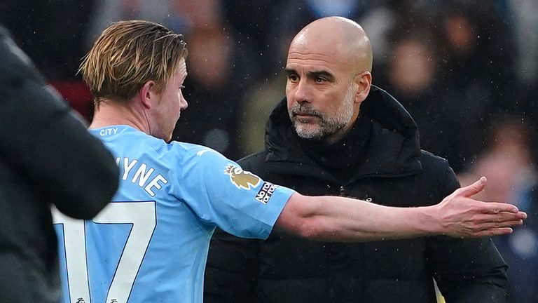 Kevin De Bruyne speaks with Pep Guardiola as he leaves the pitch and takes his seat on the Man City bench