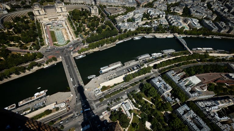 FILE - The Eiffel Towers casts its shadow on the Iena bridge, crossing the Seine river and leading to the Trocadero monument Tuesday, July 11, 2023 in Paris. The giant opening ceremony extravaganza that Paris is planning to hold on the River Seine to launch next year's Olympic Games could be moved if France is hit again in the run-up by extremist attacks, French President Emmanuel Macron said Wednesday Dec.21, 2023. The security, with tens of thousands of police and soldiers deployed, will be intense. (AP Photo/Thomas Padilla, File)