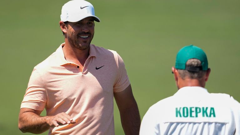 Brooks Koepka talks with his caddie on the driving range during a practice round in preparation for the Masters golf tournament at Augusta National Golf Club Monday, April 8, 2024, in Augusta, Ga. (AP Photo/George Walker IV)