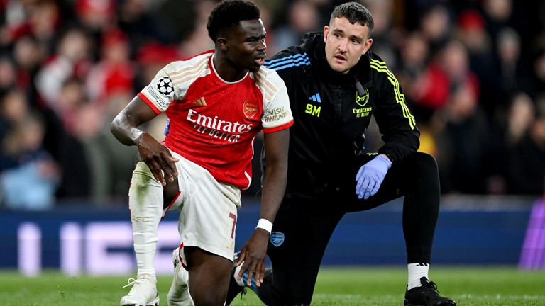 LONDON, ENGLAND - APRIL 09: Bukayo Saka of Arsenal receives medical treatment from Arsenal Physio Simon Murphy during the UEFA Champions League quarter-final first leg match between Arsenal FC and FC Bayern München at Emirates Stadium on April 09, 2024 in London, England. (Photo by Shaun Botterill/Getty Images)