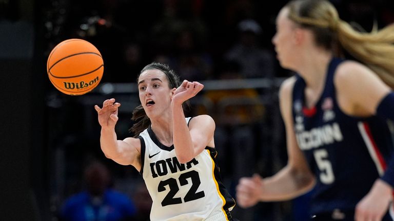 Iowa guard Caitlin Clark (22) passes up court in front of UConn guard Paige Bueckers (5) during the first half of a Final Four college basketball game in the women's NCAA Tournament, Friday, April 5, 2024, in Cleveland. (AP Photo/Carolyn Kaster)