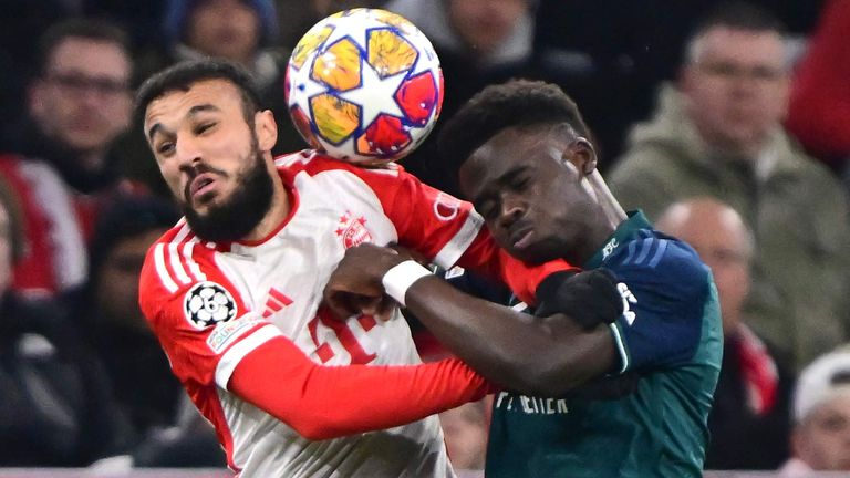 Noussair Mazraoui challenges for the ball with Bukayo Saka