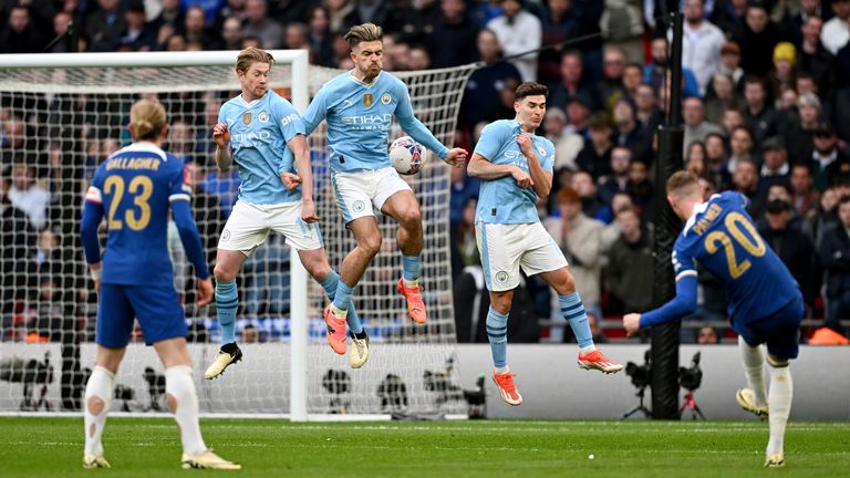Kevin De Bruyne, Jack Grealish and Julian Alvarez jump in the wall as Cole Palmer takes a free kick