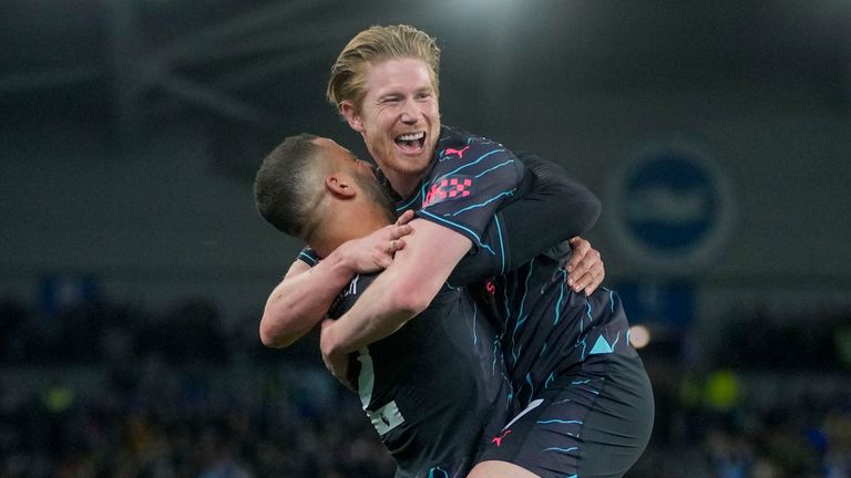 Manchester City's Kevin De Bruyne, top, celebrates with Manchester City's Kyle Walker after scoring his side's opening goal during the English Premier League soccer match between Brighton and Manchester City at the Falmer Stadium in Brighton, England, Thursday, April 25, 2024. (AP Photo/Kin Cheung)