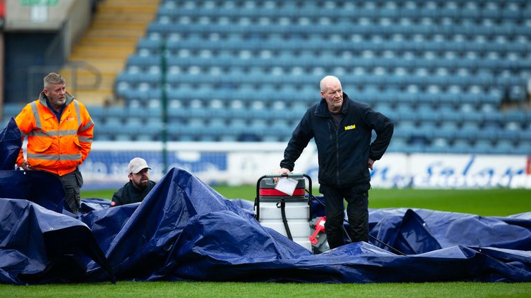 DUNDEE, SCOTLAND - APRIL 10: Dundee groundsmen remove the pitch cover during a secondary pitch inspection ahead of a cinch Premiership match between Dundee and Rangers at the Scot Foam Stadium at Dens Park, on April 10, 2024, in Dundee, Scotland. (Photo by Ewan Bootman / SNS Group)