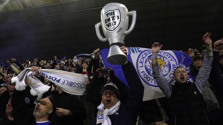 A fan holds up a inflatable of the Championship trophy, with 'The Enzo Way' written on it