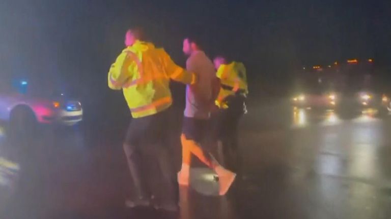 Scheffler being taken away in handcuffs by police
