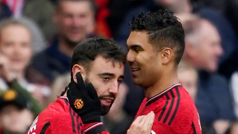 Manchester United's Bruno Fernandes, left, celebrates with Casemiro after scoring his side's first goal during the English Premier League soccer match between Manchester United and Liverpool at the Old Trafford stadium in Manchester, England, Sunday, April 7, 2024. (AP Photo/Dave Thompson)