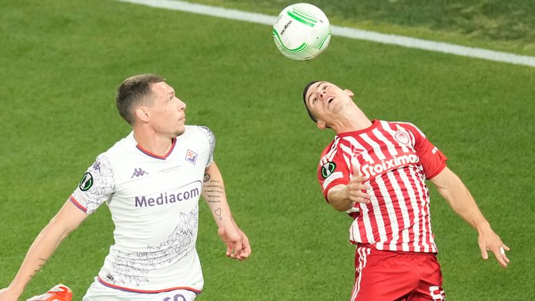 Olympiakos' Daniel Podence, right, jumps for a header with Fiorentina's Andrea Belotti during the Conference League final