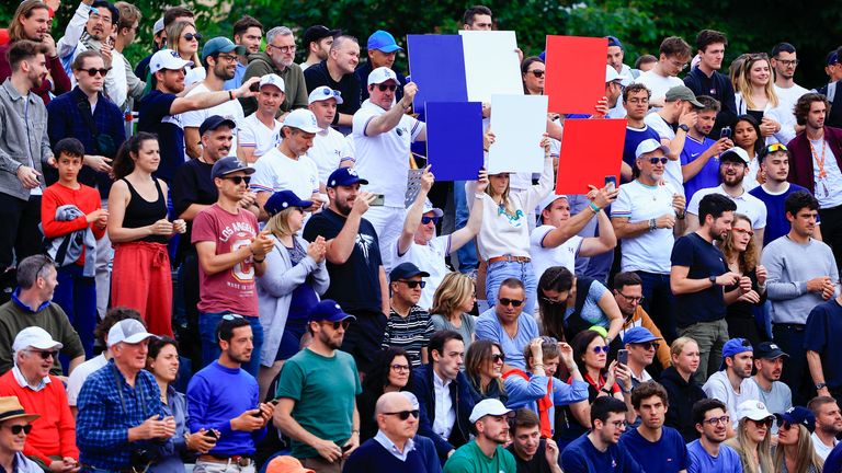 Fans of France's Hugo Gaston show the colours of the French flag during his first round match of the French Open tennis tournament against Ben Shelton of the U.S. at the Roland Garros stadium in Paris, Monday, May 27, 2024. (AP Photo/Aurelien Morissard)