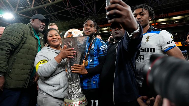 Lookman poses for a selfie with family members holding the trophy