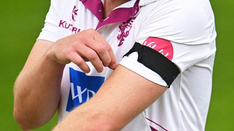 TAUNTON, ENGLAND - MAY 03: Josh Davey of Somerset looks on whilst wearing a black armband as a mark of respect to Josh Baker during Day One of the Vitality County Championship match between Somerset and Essex at The Cooper Associates County Ground on May 03, 2024 in Taunton, England. (Photo by Harry Trump/Getty Images)