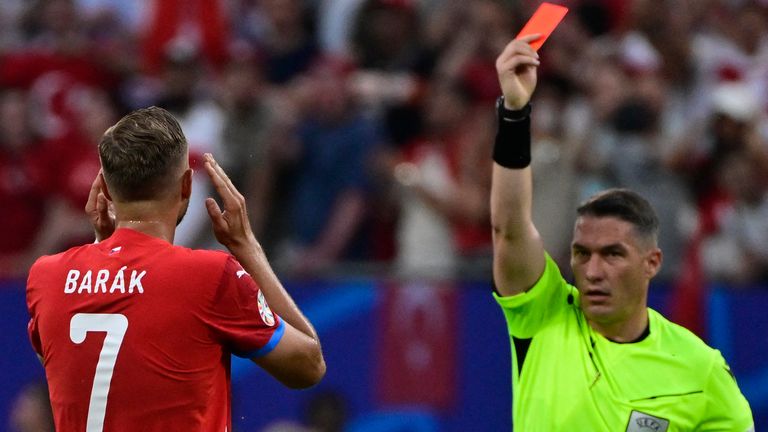 Romanian referee Istvan Kovacs gives a red card to Czech Republic's midfielder #07 Antonin Barak after two yellow cards during the UEFA Euro 2024 Group F football match between the Czech Republic and Turkey at the Volksparkstadion in Hamburg on June 26, 2024. (Photo by JOHN MACDOUGALL / AFP)