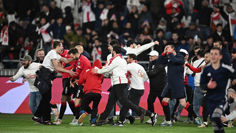 Georgia's players and team members celebrate after winning a penalty shootout at the end of the Euro 2024 qualifying play-off soccer match between Georgia and Greece at the Boris Paichadze National Stadium in Tbilisi, Georgia, Tuesday, March 26, 2024. (AP Photo/Tamuna Kulumbegashvili)