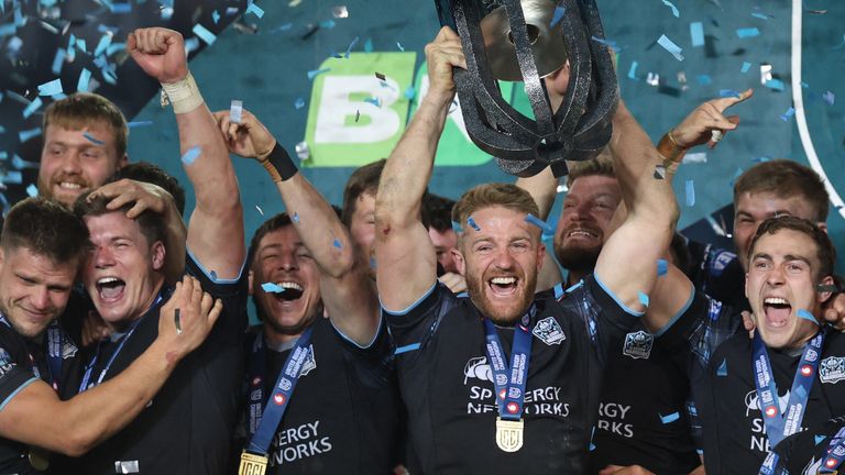 Glasgow Warriors players celebrate with the trophy after winning the United Rugby Championship (URC) final match between The Bulls (Pretoria) and Glasgow Warriors (Glasgow) at Loftus Versfeld stadium in Pretoria, on June 22, 2024. (Photo by Phill Magakoe / AFP) 