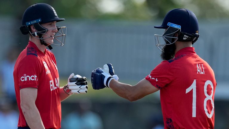 England's Harry Brook and Moeen Ali bump gloves during their partnership against Namibia at an ICC Men's T20 World Cup cricket match at Siv Vivian Richards Stadium in North Sound, Antigua and Barbuda, Saturday, June 15, 2024. (AP Photo/Ricardo Mazalan)