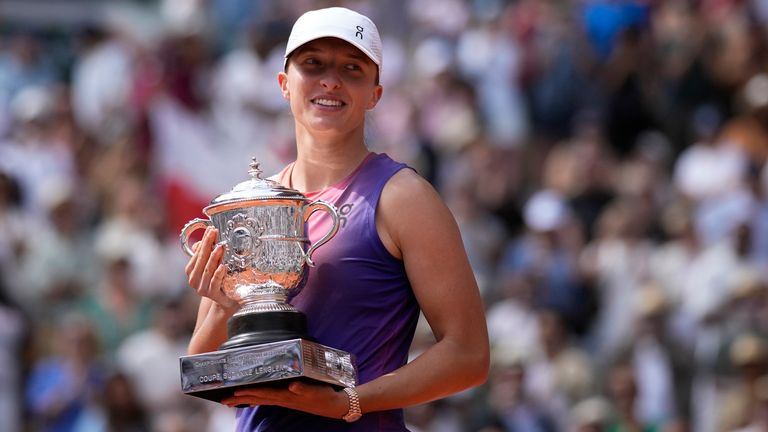 Poland's Iga Swiatek celebrates with the trophy as she won the women's final of the French Open tennis tournament against Italy's Jasmine Paolini at the Roland Garros stadium in Paris, France, Saturday, June 8, 2024. (AP Photo/Christophe Ena)