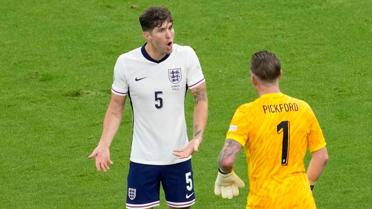 England's John Stones gestures to England's goalkeeper Jordan Pickford after Denmark's Pierre-Emile Hojbjerg had a shot at goal during a Group C match between Denmark and England at the Euro 2024 soccer tournament in Frankfurt, Germany, Thursday, June 20, 2024. (AP Photo/Darko Vojinovic)