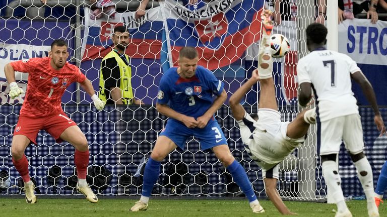 Angličan Jude Bellingham strieľa prvý gól svojho tímu z dvojitého kopu nad hlavou počas osemfinále medzi Anglickom a Slovenskom na turnaji Euro 2024 v nemeckom Gelsenkirchene, nedeľa 30. júna 2024. (AP Photo/Thanassis Stavrakis)