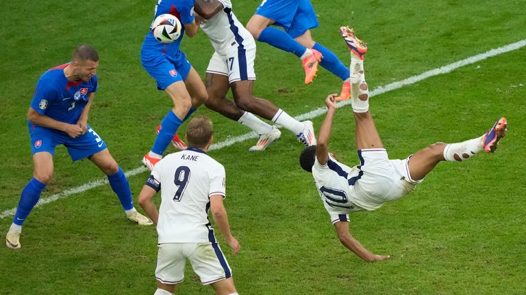 England's Jude Bellingham, right, scores his side's first goal with an overhead kick during a round of sixteen match between England and Slovakia at the Euro 2024 soccer tournament in Gelsenkirchen, Germany, Sunday, June 30, 2024. (AP Photo/Ebrahim Noroozi)