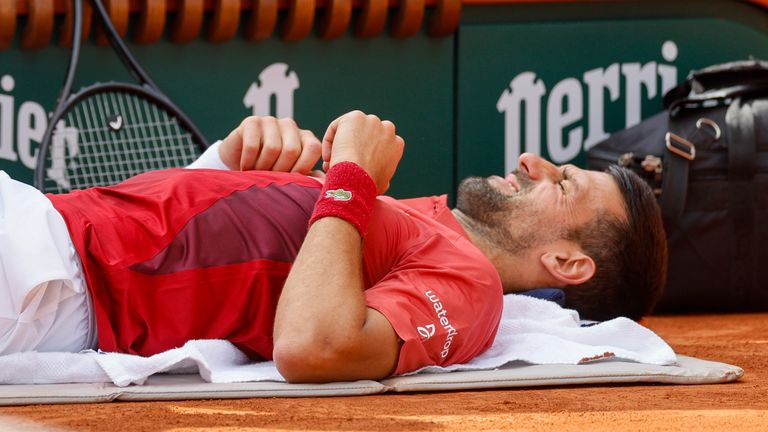 Serbia&#39;s Novak Djokovic receives medical assistance for his right knee during his fourth round match of the French Open tennis tournament against Argentina&#39;s Francisco Cerundolo at the Roland Garros stadium in Paris, Monday, June 3, 2024. (AP Photo/Jean-Francois Badias)