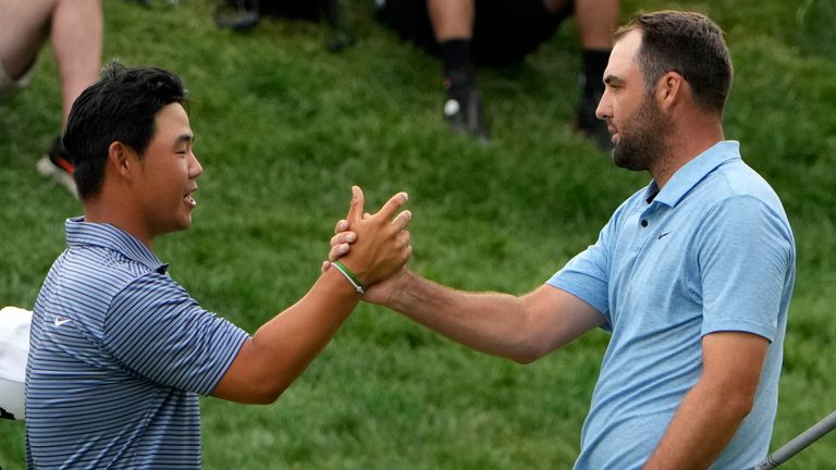 Scottie Scheffler, right, shakes hands with Tom Kim, of South Korea, after winning the Travelers Championship golf tournament at TPC River Highlands, Sunday, June 23, 2024, in Cromwell, Conn.  (AP Photo/Seth Wenig)