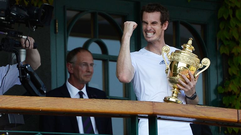 Andy Murray of Great Britain punches the air on the Centre court balcony as he holds the Gentlemen's Singles Trophy following his victory in the Gentlemen's Singles Final match against Novak Djokovic of Serbia on day thirteen of the Wimbledon Lawn Tennis Championships at the All England Lawn Tennis and Croquet Club on July 7, 2013 in London, England. (Photo by Dennis Grombkowski/Getty Images)