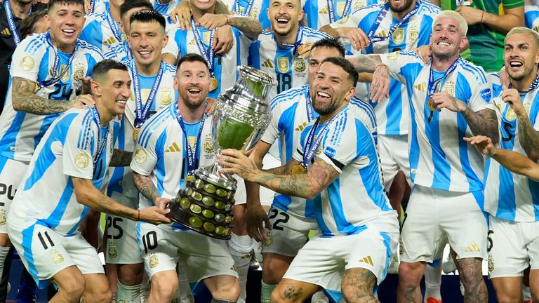 Argentina players Angel di Maria, left, Lionel Messi, second from left, and Nicolas Otamendi, third from left, celebrate with the trophy after defeating Colombia in the Copa America final soccer match in Miami Gardens, Fla., Monday, July 15, 2024. (AP Photo/Rebecca Blackwell)