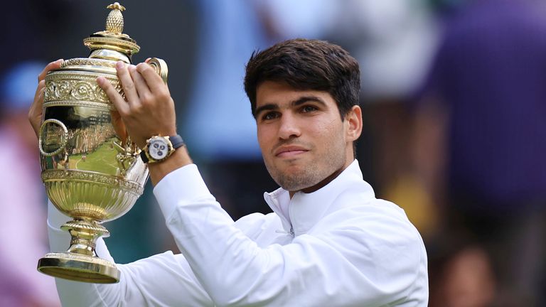 Carlos Alcaraz of Spain holds a trophy after winning the men's singles final against Novak Djokovic of Serbia on day 14 of the Wimbledon Tennis Championships at the All England Lawn Tennis and Croquet Club in London, Britain, July 14, 2024. Carlos Alcaraz won the match to claim his consecutive win. (The Yomiuri Shimbun via AP Images)