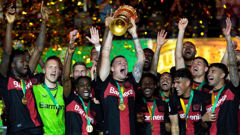 Leverkusen's Granit Xhaka lifts the trophy after the German Soccer Cup final match between 1. FC Kaiserslautern and Bayer Leverkusen at the Olympic Stadium in Berlin, Germany, Saturday, May 25, 2024. (AP Photo/Matthias Schrader)