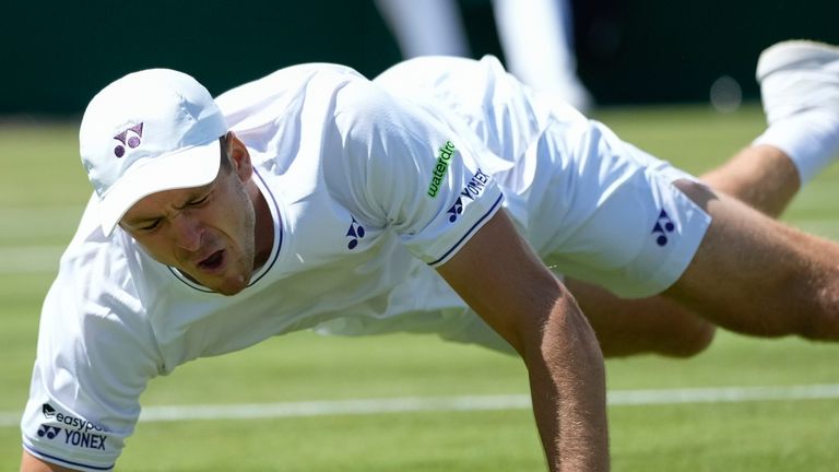 Hubert Hurkacz of Poland falls attempting to return a shot to Arthur Fils of France during their second round match at the Wimbledon tennis championships in London, Thursday, July 4, 2024. (AP Photo/Mosa'ab Elshamy)
