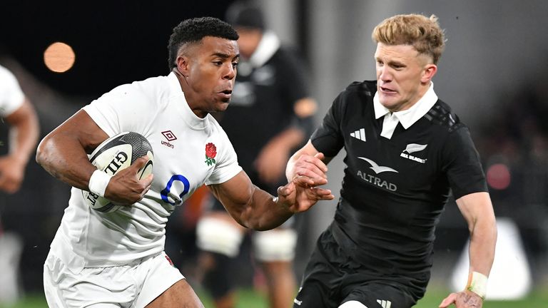 England's Immanuel Feyi-Waboso (L) runs with the ball as New Zealand's Damian McKenzie attempts to tackle him during the rugby union Test match between the New Zealand All Blacks and England at Forsyth Barr Stadium in Dunedin on July 6, 2024. (Photo by Sanka Vidanagama / AFP)