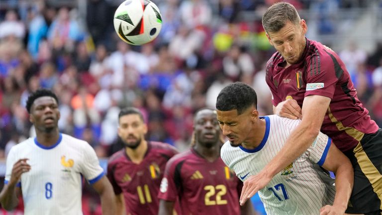 Belgium's Jan Vertonghen, top, jumps for the ball above William Saliba of France during a round of sixteen match between France and Belgium at the Euro 2024 soccer tournament in Duesseldorf, Germany, Monday, July 1, 2024. (AP Photo/Darko Vojinovic)
