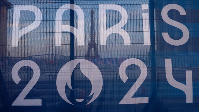 The Eiffel Tower is seen behind a Paris Olympics canvas, from the Trocadero plaza Thursday, July 18, 2024 in Paris. (AP Photo/David Goldman)