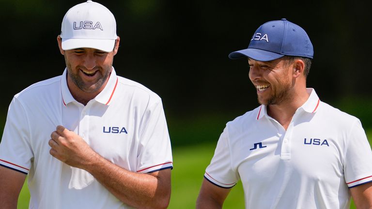 Scottie Scheffler (L) and Xander Schauffele (both United States) smile on the 13th green during a practice round for the men's golf tournament at the 2024 Summer Olympics, Wednesday, July 31, 2024, at Le Golf National in Saint-Quentin-en-Yvelines, France. (AP Photo/George Walker IV)